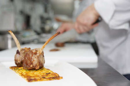 Half done meat dish with chef  in background, professional kitchenの写真素材