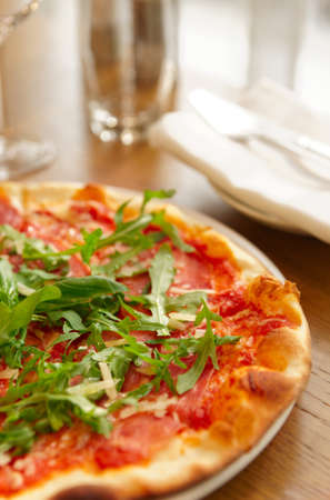 Pizza with arugula on restaurant tableの写真素材