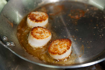 Scallops being seared on hot panの写真素材