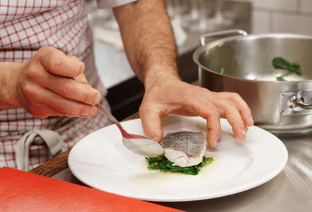 Chef is serving steamed seabass with spinachの写真素材