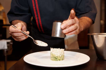Chef is serving appetizer with metal ring, motion blur on gandsの写真素材