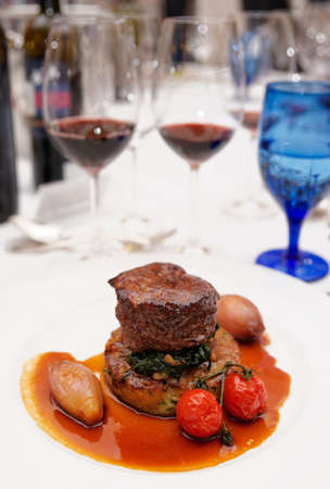 Red wines and tenderloin steak on restaurant tableの写真素材