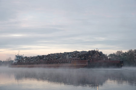 Barge ship loaded with scrap metal on river