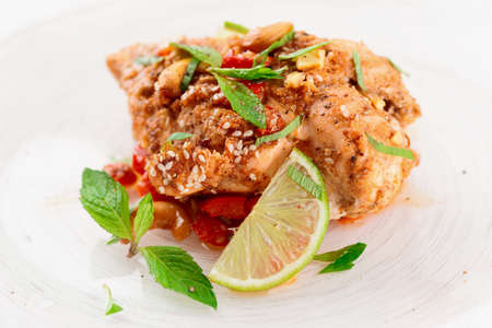 Chicken breast cooked in asian style with hot sauce, nuts and mintの写真素材