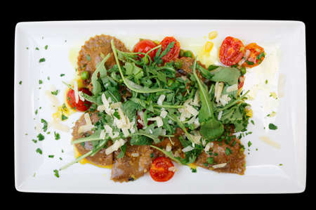 Rabbit ravioli with rocket salad isolated on black backgroundの写真素材
