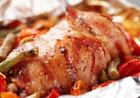 Chicken breast wrapped in bacon and fried with vegetablesの写真素材