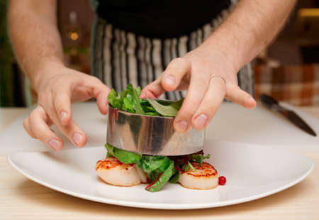 Chef is cooking appetizer with sea scallops and salad mixの写真素材