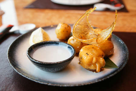 Caramelized fruits in dough, chinese dessert, in plate on restaurant tableの写真素材
