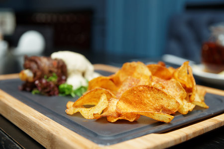 Potato chips and meat rolls on pub table
