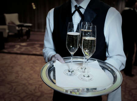 Waiter welcomes guests with champagneの写真素材