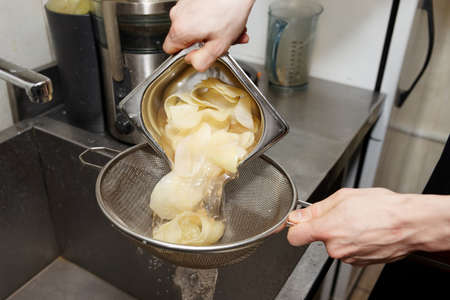 Chef is preparing potato chips on restaurant kitchenの写真素材