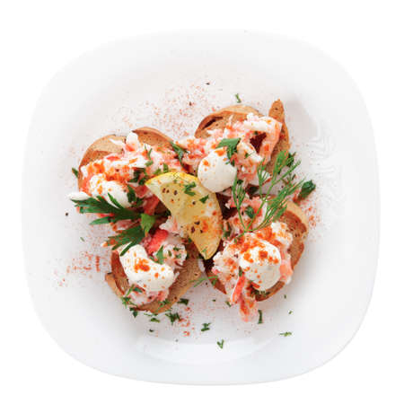 Crab meat with toast, sauce and fresh herbs in plate, isolatedの写真素材