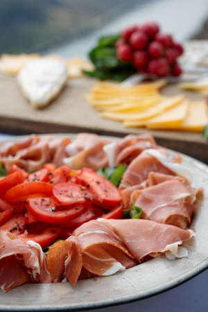 Platter with cured ham on table, radish and cheeseの写真素材