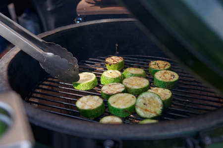 Zucchini being fried on grill at outdoor kitchenの写真素材