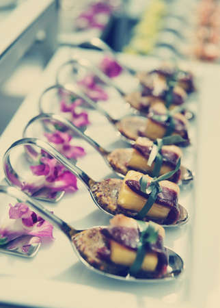 Canapes with cured ham (jamon or prosciutto) on banquet table, selective focus, toned imageの写真素材