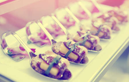 Canapes with cured ham on banquet table, selective focus, toned imageの写真素材