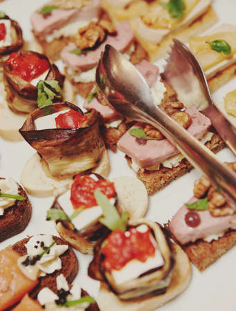 Various snacks in plate on banquet table, toned imageの写真素材