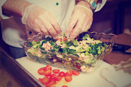 Chef is making an appetizer at professional kitchen, toned imageの写真素材