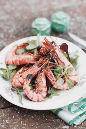 Grilled shrimps served outdoor in winter, snow on table, toned imageの写真素材