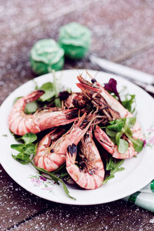 Grilled shrimps served outdoor in winter, snow on table, toned imageの写真素材