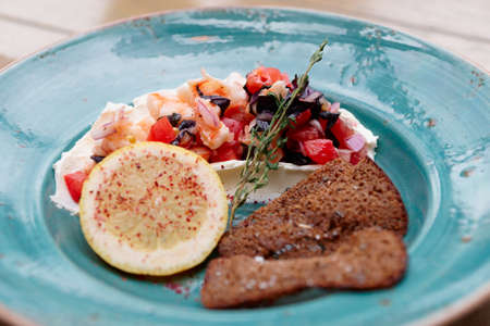 Appetizer of shrimps, tomatoes and sour cream with rye bread toastsの写真素材