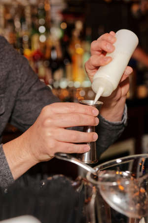 Bartender is adding secret ingredient in a cocktailの写真素材