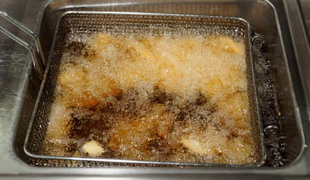 Deep fryer with boiling oil at commercial kitchen