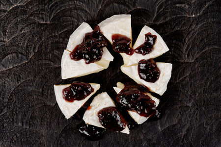 Brie cheese with jam shot from above on wooden plank