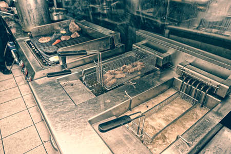 Deep fryers and grill, equipment of a fast food restaurant, toned imageの写真素材