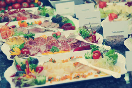 Meat, fish and fruits in expensive hotel restaurant, toned imageの写真素材