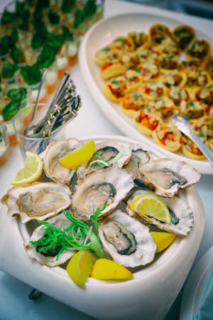 Fresh oysters and another dishes on restaurant tableの写真素材