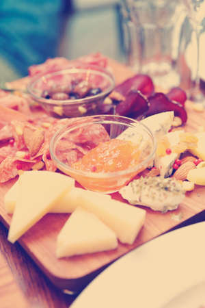 Cheese and sausage platter with nuts and citrus jam, toned imageの写真素材