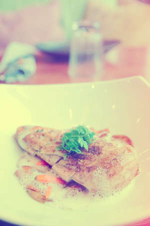 Fried chicken breast with baby vegetables on plateの写真素材