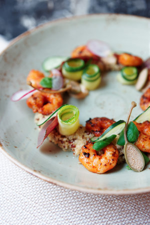Healthy appetizer with quinoa and seafood on restaurant table