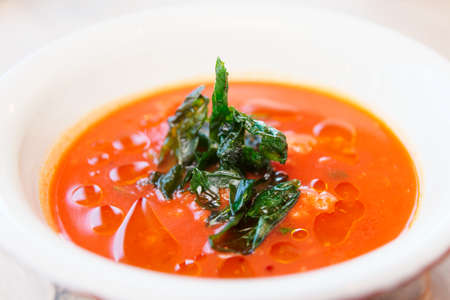 Tomato soup with dried spinach, close-upの写真素材