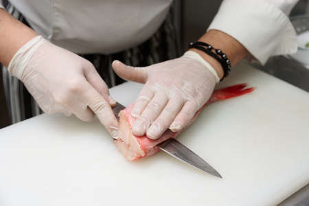 Chef is filleting red snapper fish at commercial kitchenの写真素材