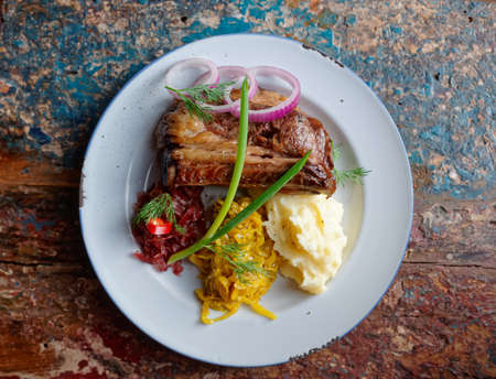 Grilled pork ribs with sauerkraut and mash potatoes on grunge peeled paint surface - hearty dishの写真素材