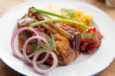 Grilled pork ribs with sauerkraut and mashed potatoes on restaurant tableの写真素材