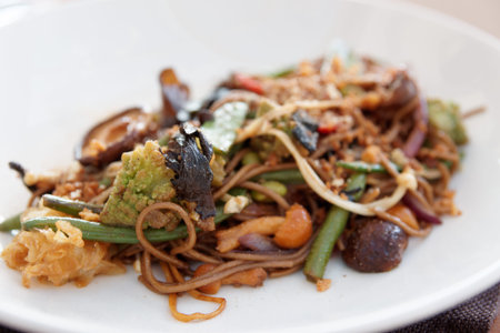 Buckwheat noodles with vegetables and mushrooms, Asian style dish on white plate