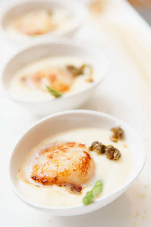 Grilled sea scallop with thick creamy sauce, close-upの写真素材