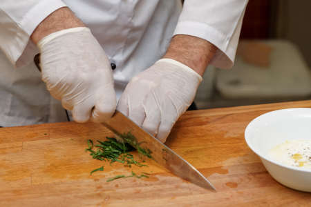 Chef is cutting herbs, professional cooking, routine kitchen operationの写真素材