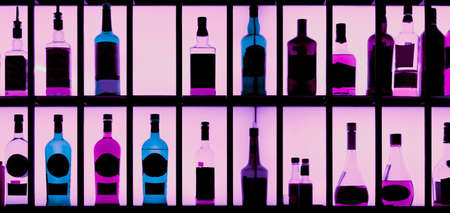 Various hard alcohol bottles in a bar, back lighting, toned imageの写真素材