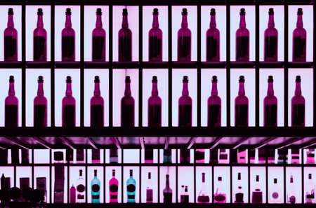 Various alcohol bottles in a bar, back lighting, toned imageの写真素材