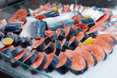 Salmon steaks and fillet on iced food market displayの写真素材