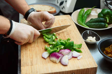 Chef is cutting vegetables at commercial kitchenの写真素材