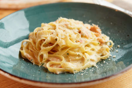 Pasta carbonara with parmesan cheese in clay plateの写真素材