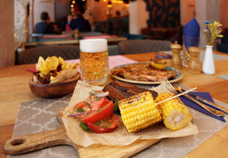Potato chips and grilled goods on table in a pub, Cajun style foodの写真素材
