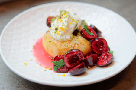 Grilled peach, sweet cherries, mint and whipped cream - healthy fruit dessertの写真素材
