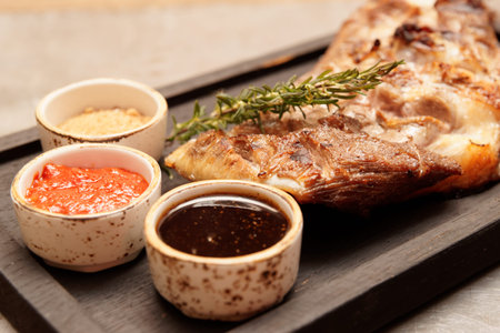 Grilled lamb meat with sauces, close-up