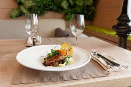 Fried duck dish on restaurant table, place settingの写真素材